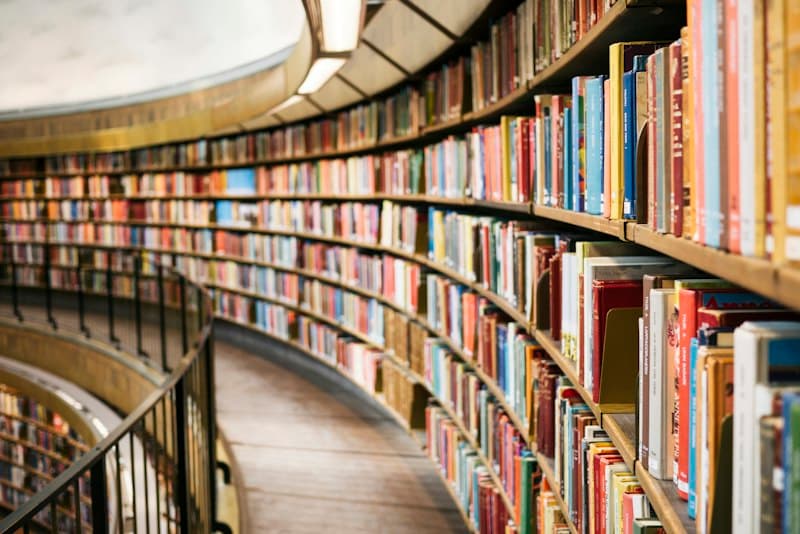A curved wall of bookshelves filled with colourful books