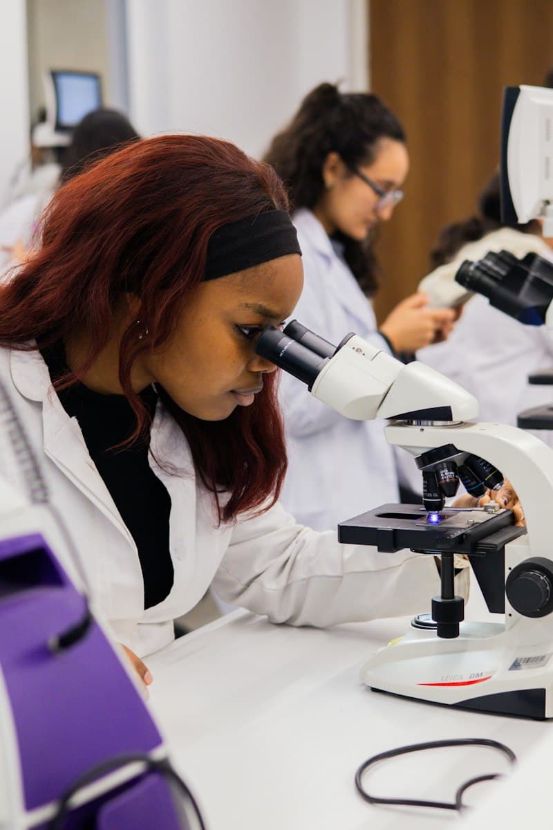 A student looking through a microscope in a science laboratory