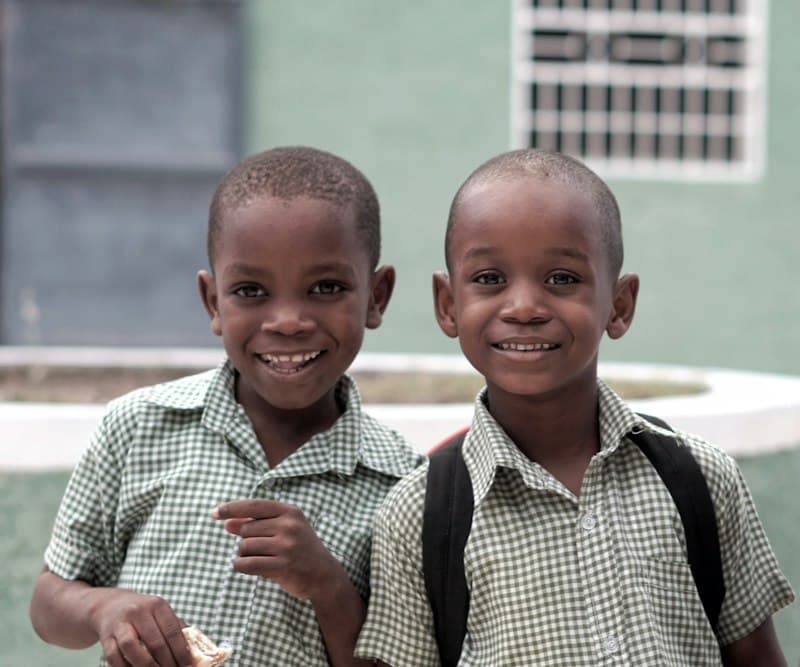 Two smiling boys in checked school uniforms